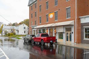 Hudson apartment for rent - Two trucks are parked in front of a building.