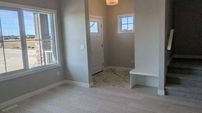 Chestermere house for rent - A room with a large window, a door, and a staircase.