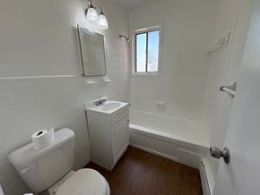 Washington apartment for rent - A white toilet with a roll of toilet paper on top sits in a bathroom with white tiles.