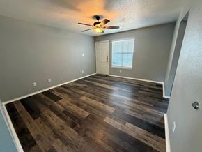 Killeen apartment for rent - A room with a ceiling fan and wooden flooring.