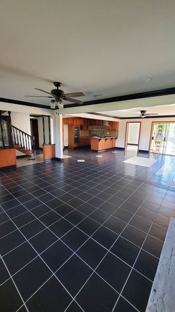 Carson house for rent - A spacious room with a black tile floor and a ceiling fan.
