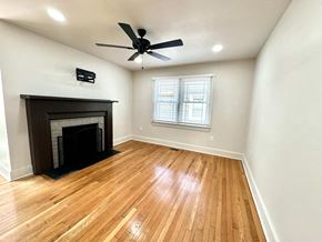 Greenville house for rent - A room with a fireplace and a ceiling fan.