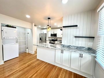 Greenville house for rent - A kitchen with white cabinets and a marble countertop.