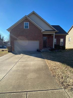 Nashville house for rent - A red brick house with a white garage door and a driveway.