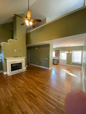 Nashville house for rent - A living room with a fireplace and a ceiling fan.