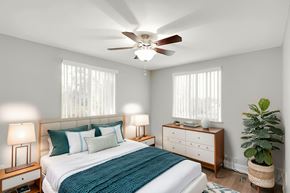 Lakewood apartment for rent - A bedroom with a bed, nightstands, and a ceiling fan.