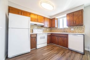 Lakewood apartment for rent - A kitchen with wooden cabinets and a white refrigerator.