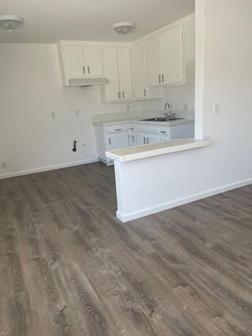 Westminster apartment for rent - A kitchen with white cabinets and a wooden floor.
