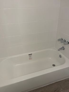 Westminster apartment for rent - A white bathtub with a shower head and a faucet.