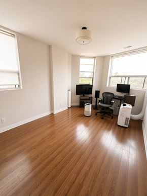 Toronto apartment for rent - A room with wooden floors and two computer desks with chairs.