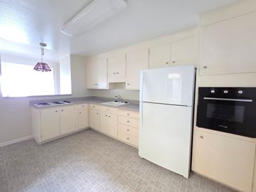 Richmond apartment for rent - A kitchen with white appliances and cabinets.