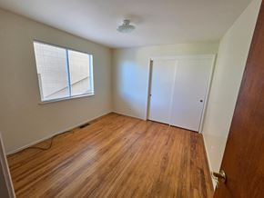 Richmond apartment for rent - A room with wooden flooring and a window with blinds.