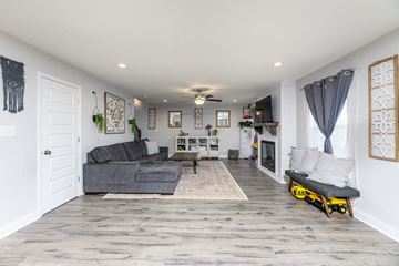Clarksville house for rent - A living room with a grey couch and a white door.