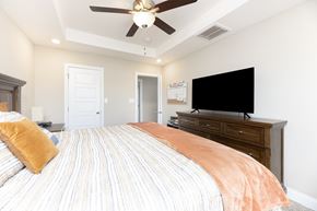 Clarksville house for rent - A bedroom with a bed, dresser, and ceiling fan.
