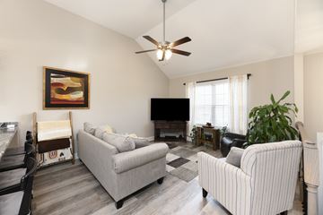 Clarksville house for rent - A living room with a striped couch and a television.