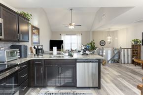 Clarksville house for rent - A kitchen with dark cabinets and a stainless steel dishwasher.
