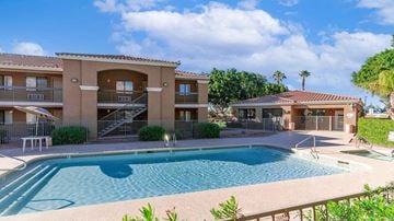 Phoenix apartment for rent - A swimming pool in front of a building with a clear blue sky.