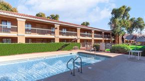 Phoenix apartment for rent - A swimming pool is in front of a building with a red roof.