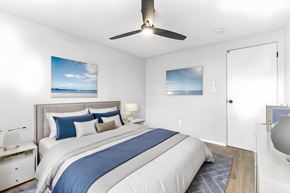 Denver apartment for rent - A bedroom with a large bed and a ceiling fan.