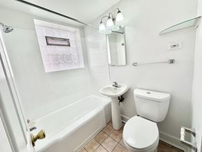 Denver apartment for rent - A white toilet sits next to a white sink in a small bathroom.