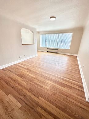Denver apartment for rent - A room with wooden flooring and a window with blinds.