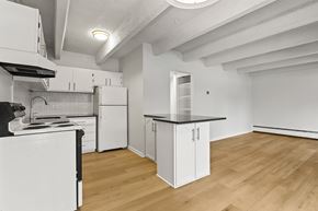 Denver apartment for rent - A kitchen with white cabinets and a black stove top oven.