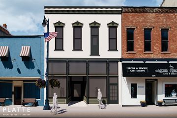 Van Wert apartment for rent - A street scene with a blue building on the left and a white building with a sign that reads "Decor & More Gift Shoppe" on the right.