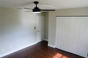Weirsdale house for rent - A room with a ceiling fan and a white door.