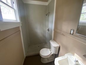 Mobile house for rent - A white toilet sits in a bathroom next to a white sink.