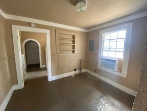 Mobile house for rent - A room with a window and a doorway leading to another room.