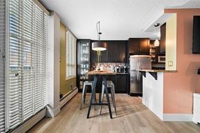 Calgary apartment for rent - A kitchen with a table and chairs in the middle of the room.