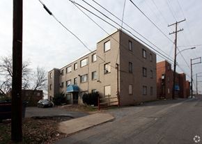 Washington apartment for rent - A street view of a residential area with apartment buildings and a car parked on the side of the road.