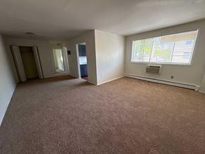 Washington apartment for rent - A room with a carpeted floor and a window with blinds.