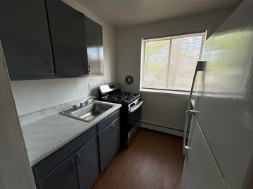 Washington apartment for rent - A small kitchen with a sink, stove, and refrigerator.