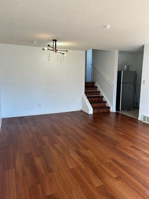 Edmonton house for rent - A room with wooden flooring and a staircase.