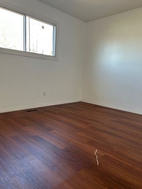 Edmonton house for rent - A room with a wooden floor and a window.