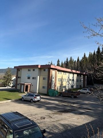 Fort St James apartment for rent - A carport with a black car in front of a two-story building.