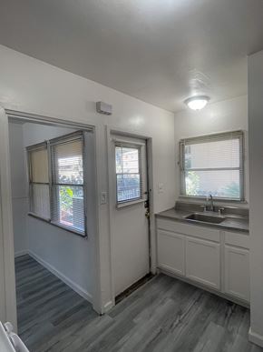 Riverside apartment for rent - A small white bathroom with a sink and a window.
