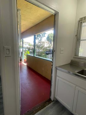Riverside apartment for rent - A kitchen with a red floor and white cabinets.