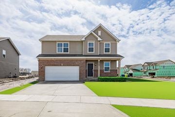 Winfield house for rent - A house with a grey garage door is in front of a green field.