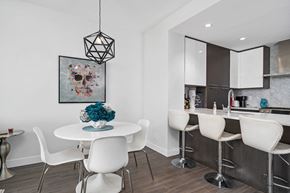 Calgary apartment for rent - A dining room with a white table and chairs and a skull picture on the wall.