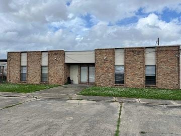 Thibodaux apartment for rent - A brick building with a grey roof and a white door.