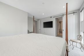 Santa Clara house for rent - A bedroom with a bed, chair, and mirror.