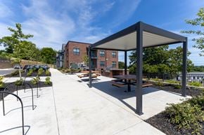Knoxville apartment for rent - A covered picnic area with benches and a playground in the background.