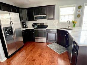 Prospect house for rent - A kitchen with black cabinets and a wooden floor.