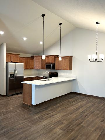 Lincoln house for rent - A kitchen with wooden cabinets and a white island.