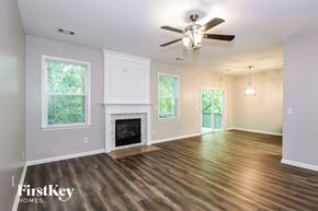 Gainesville house for rent - A spacious room with a fireplace and wooden flooring.