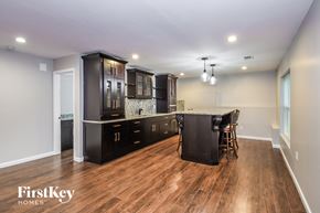 Gainesville house for rent - A kitchen with wooden floors and a black cabinetry.