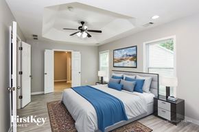 Gainesville house for rent - A bedroom with a bed, a ceiling fan, and a painting on the wall.