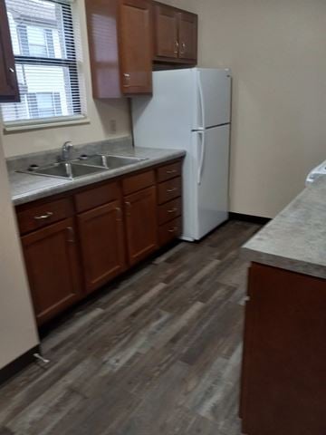 East Liverpool apartment for rent - A kitchen with a white fridge and wooden cabinets.
